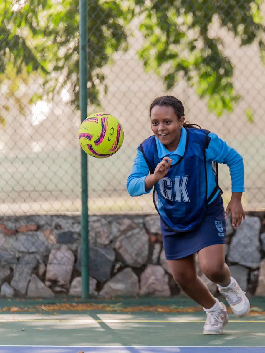 A netball player racing forward on the court