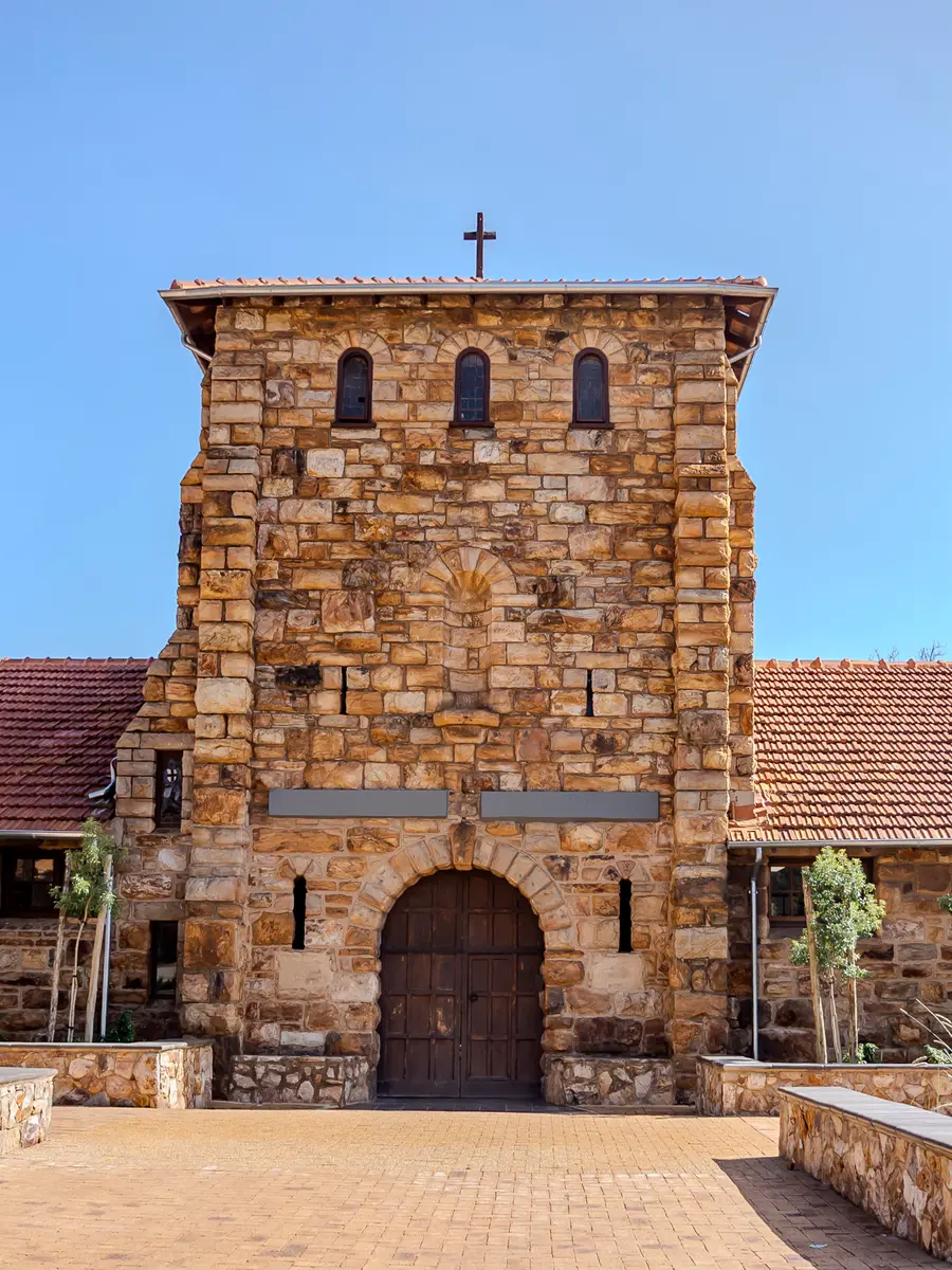 The stone bell tower of the Herbert Baker building, topped with a cross