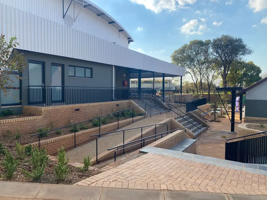 The school hall and gymnasium, with ramps, steps and new gardens leading up to it