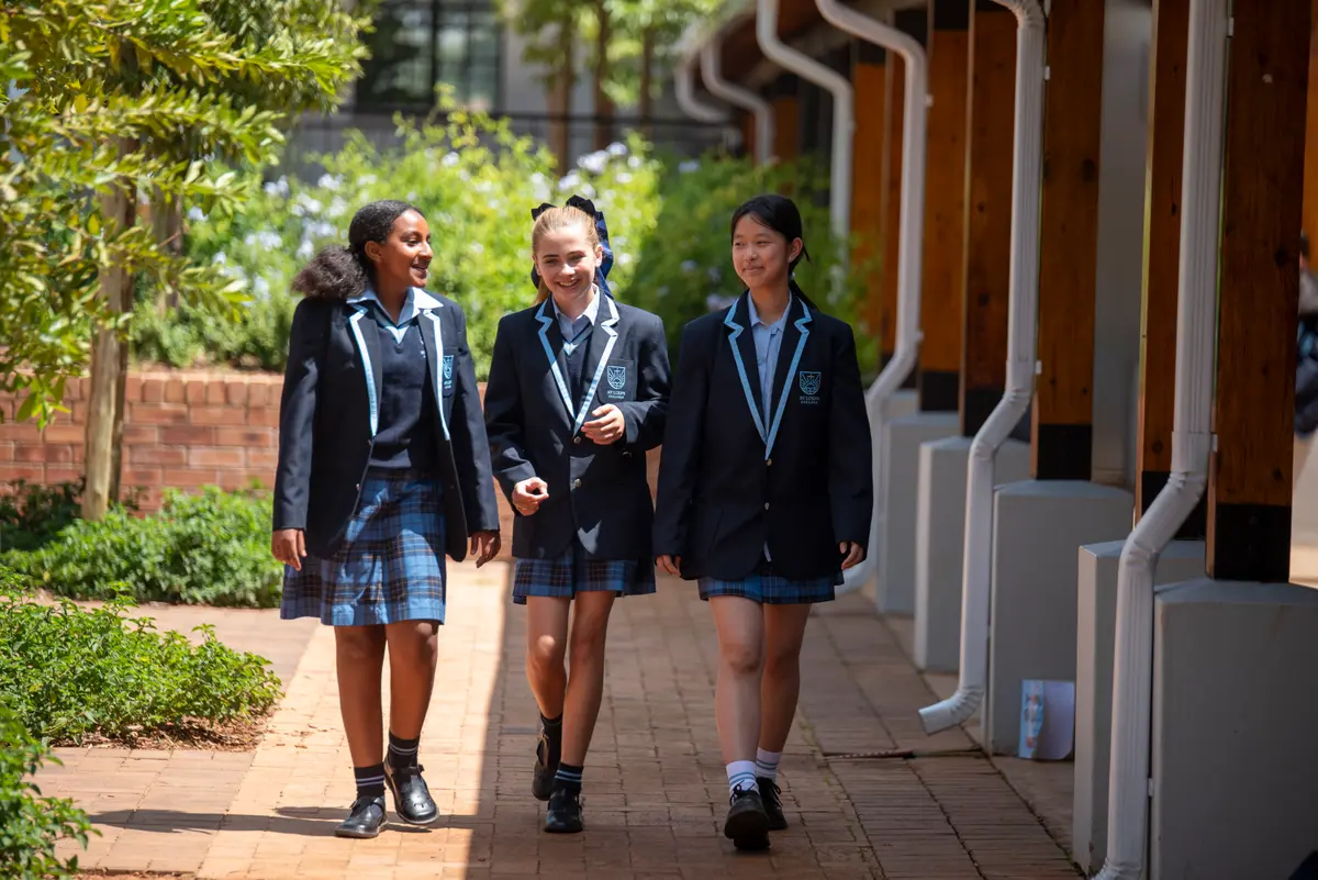 Three High School students walking together along a garden walkway