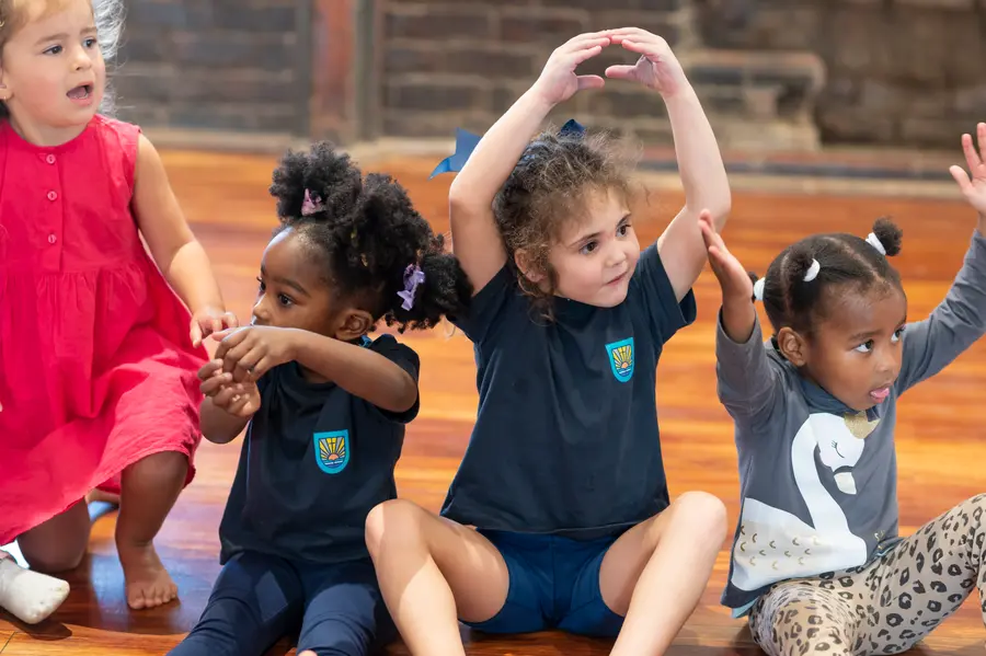 Preschool children stretching their arms up during a movement class