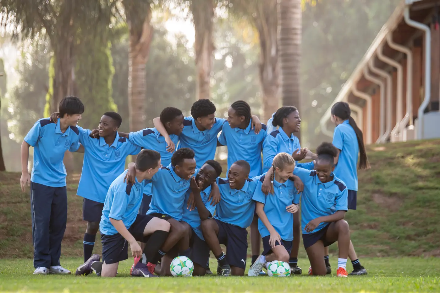 A soccer team in St Luke's kit celebrating together on the field